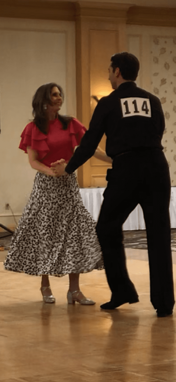 Ballroom dancers, woman in leopard print skirt. Dancing through Impostor syndrome.
