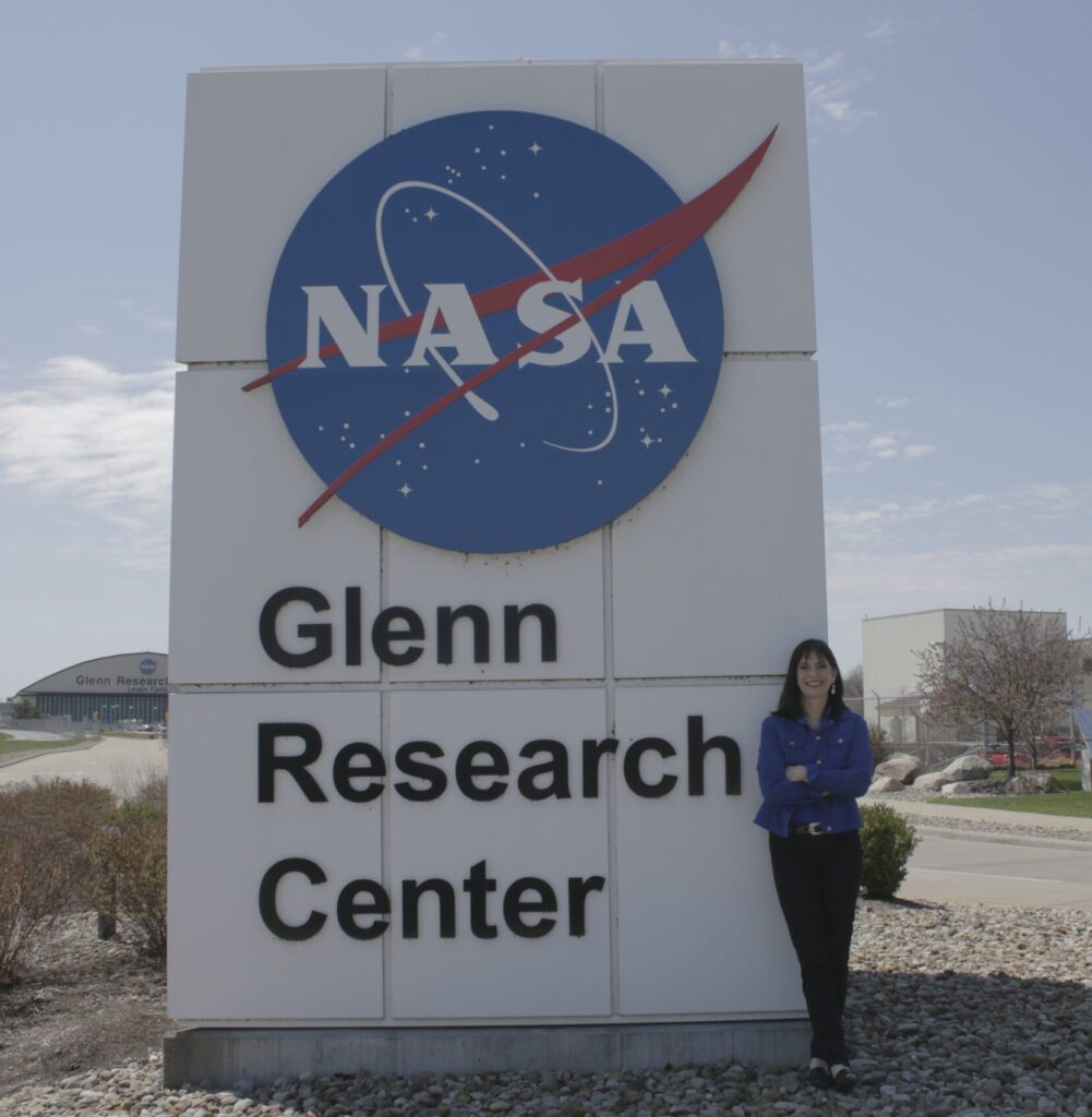 Woman stands by the NASA Glenn Research Center sign.