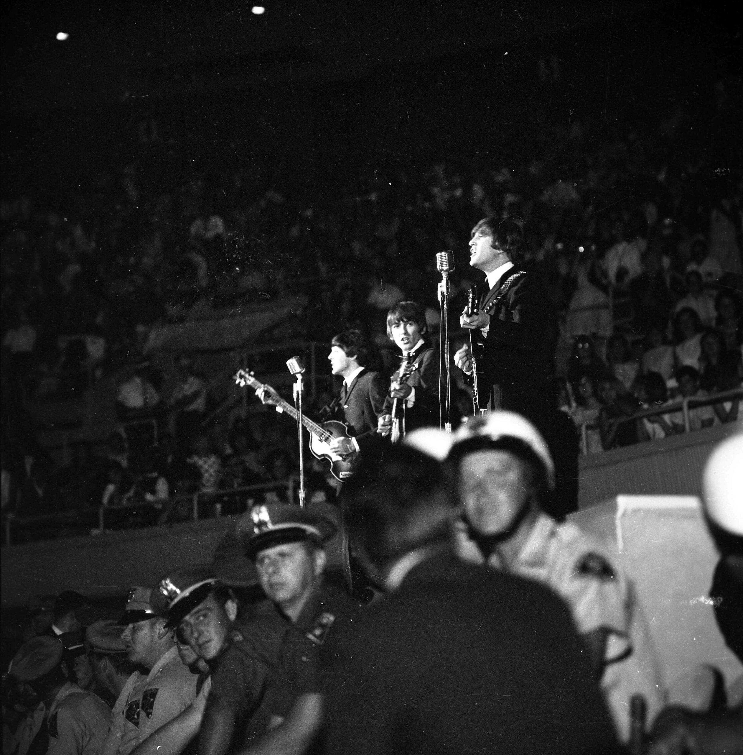 The Beatles perform at the Las Vegas Convention Center in August 1964 with police stationed in front of the stage.