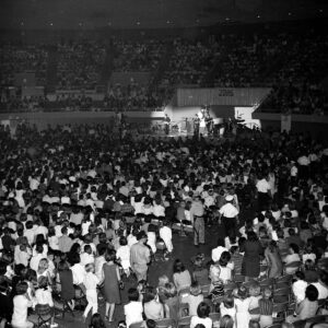 A packed Las Vegas Convention Center watches The Beatles perform onstage in August 1964.