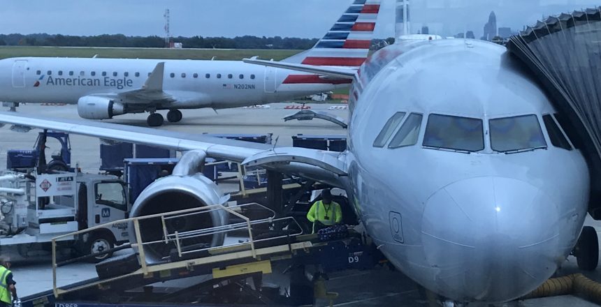 American Eagle planes at an airport gate, one being serviced. Includes text "American Eagle" and "Power Stow.